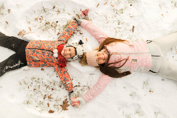 Close up of happy family lying on snow and make angel