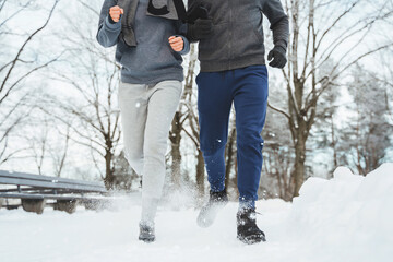 Fototapeta na wymiar Sportive couple during winter jogging in city park
