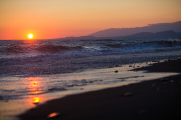 beautiful sunset by the sea with strong waves