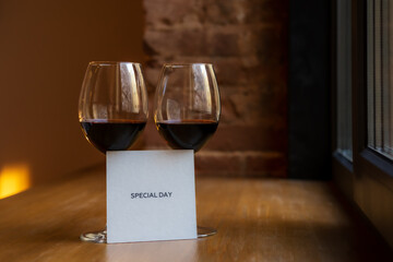 Two glasses of wine and paper with the inscription special day.