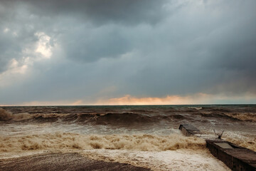 Storm waves near the shore on the beach. In the foreground, breakwaters.