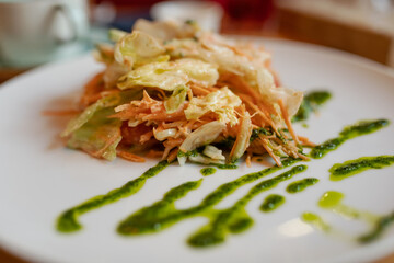 a salad of cabbage and carrots with a sauce of chopped greens