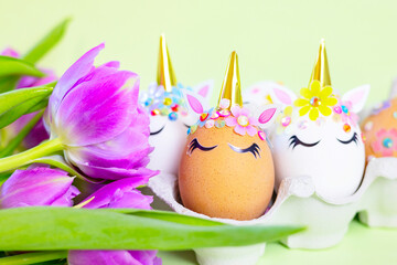 brown and white Easter eggs decorated in the form of unicorns on a green and yellow background with...