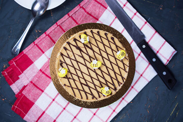 honey cake with edible bees on top on a checkered red towel. concept for birthday, meeting with parents, holidays.