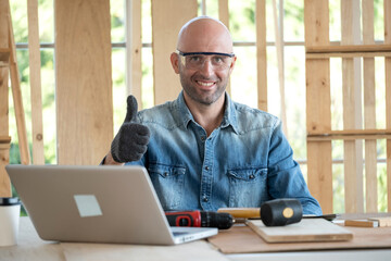 Confident senior craftsman carpenter wearing goggle and glove in the wood workplace. Looking...