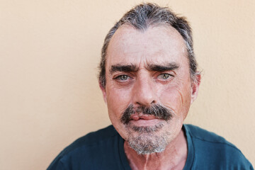 Portrait of senior man looking at camera with yellow background - Focus on face