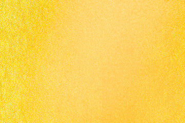Fototapeta premium Gold wall texture background. Yellow shiny gold foil paint on wall surface with light reflection,