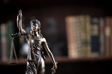 Law concept. Lawyer office. Themis statue on the shelf with legal books background. 