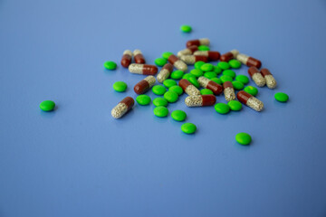 Various tablets and capsules, syringe, protective masks, on a blue background