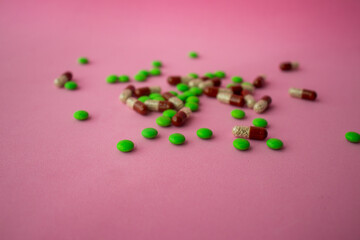 a bunch of different pills vitamins pills and capsules are lying on the table on a pink background close up view from above