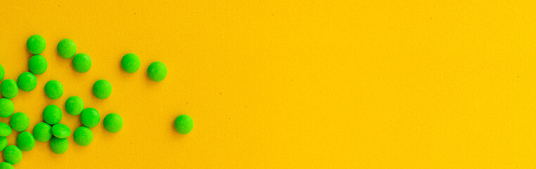 green pills on a yellow background