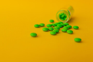 green pills on a yellow background