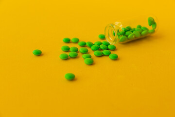 green pills on a yellow background