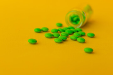 green pills on a yellow background