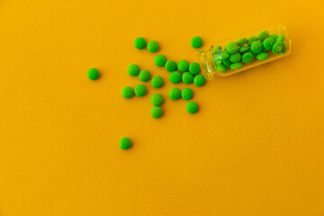green pills on a yellow background