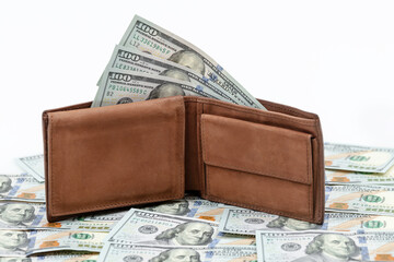 Men's purse with money. Brown suede wallet with bunch of american dollar banknotes lies on one hundred dollar bills