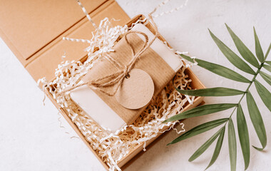 Fototapeta na wymiar Soap in Craft eco Gift box or present box with bow on white background with mockup label tag. Copy space for text and design. Package, zero waste, plastic free, eco friendly concept.