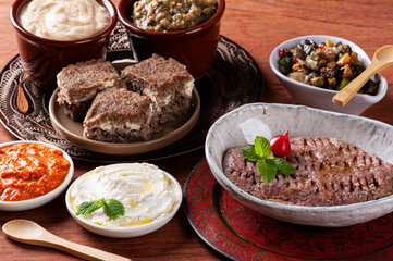 .Meze is an oriental set of appetizers served in small bowls with babaganoush, curd, hummus, muhammara and kibbeh
