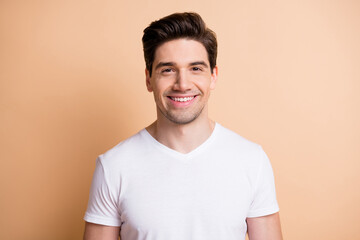 Photo of happy charismatic young man beaming smile good mood isolated on pastel beige color background