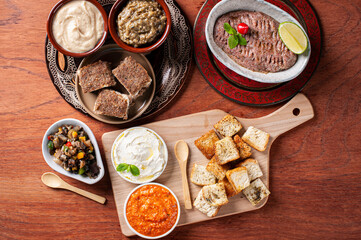 .Meze is an oriental set of appetizers served in small bowls with babaganoush, curd, hummus, muhammara and kibbeh