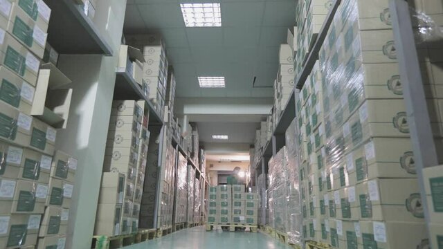 Warehouse with boxes in a factory. A modern warehouse in a factory. Two workers in a factory warehouse.