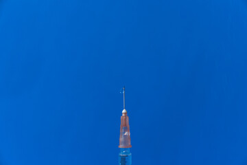 The needle of a syringe with a vaccine close-up on a blue background