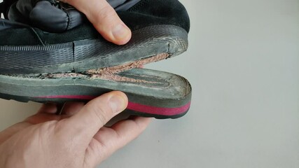 A shoemaker repairs a shoe, showing how the sole of a shoe came off