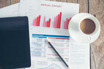 Office laptop business financial document chart and graph on wooden table with coffee cup. Flat lay notebook computer laptop on office desk. No people business graph chart mockup on business workspace