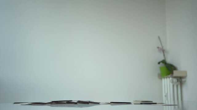 Collapsing house of cards on a white table. 4k