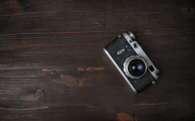 Top view of old vintage photo camera on wooden background. Flat lay.