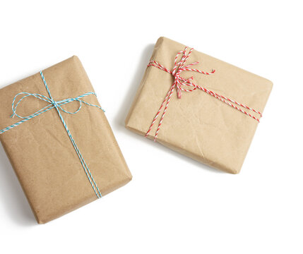 box wrapped in brown kraft paper and tied with rope, gift on white background