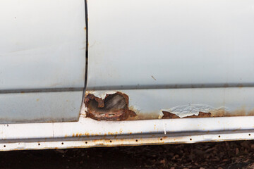 Rust on metal parts of the car body. Corrosion of cars as a result of deicing roads with chemical reagents in St. Petersburg.