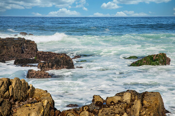 Beautiful seascape of the Pacific coast in California, waves, rocks, sky, sun. Concept, perfect postcard and guide.