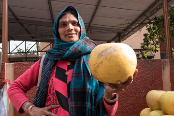 An Indian woman rejoices in a rich citrus harvest.  Traditional fruit market in India