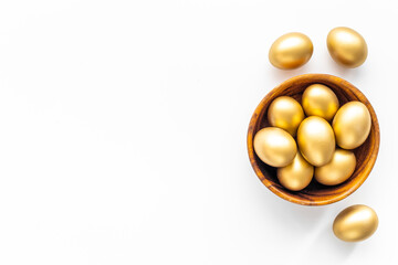 Golden eggs in wooden bowl. Wealth and good luck concept. Easter decoration