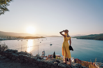 Enjoying vacation in Greece. Young traveling woman enjoying sunset on sea view point. © Loginova