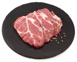 sliced raw pork meat with peppercorn  on black round stone plate isolated on white background. Clipping path and full depth of field