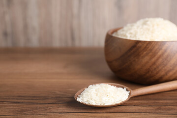 Uncooked rice on wooden table. Space for text
