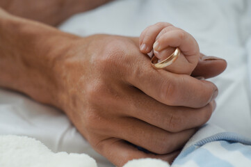 baby hand holding wedding ring