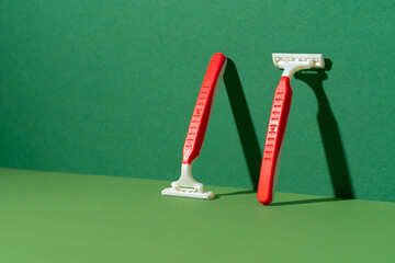 Disposable razor on green background, studio shot