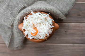 Fototapeta na wymiar chopped sauerkraut on wooden table with sackcloth