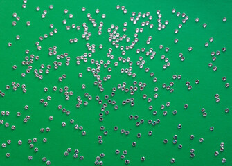 rhinestones on a green background, top photo. design for text