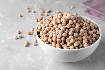 Chickpeas in bowl on light grey table, space for text