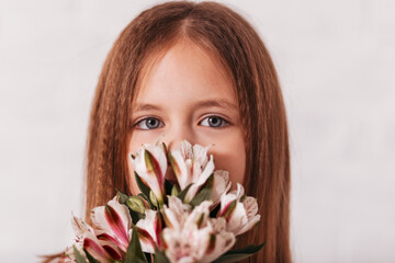 Beautiful girl with a bouquet of pink spring flowers close-up