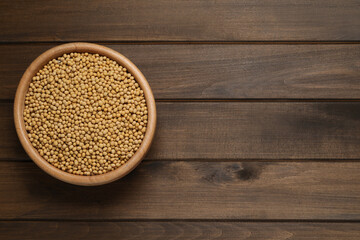 Soy in bowl on wooden table, top view. Space for text