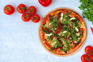 Fresh pizza with herbs and sun dried tomatoes on gray table