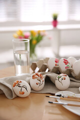 Beautifully painted Easter eggs on wooden table indoors