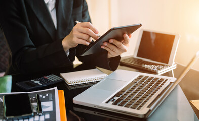 businessman using a tablet, smartphone during sunrise overlay with cityscape image.