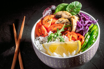 Green vegan salad, rice and vegetable power bowl on a dark background. Healthy balanced food concept. Buddha bowl. Diet food