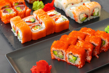 Set of various sushi rolls served on gray background